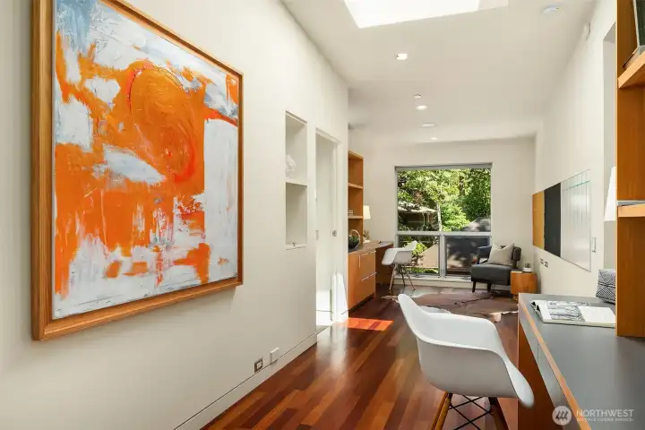 The upstairs landing doubles as an office and flex space, with built-in desks on both sides, a skylight, and workspace for two or more.