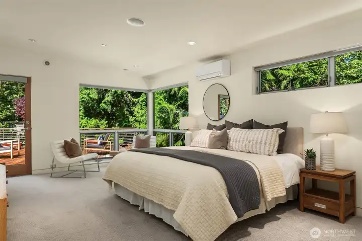 The primary suite wraps two walls in glass and opens directly to the roof deck — waking up here feels like waking up in the canopy.