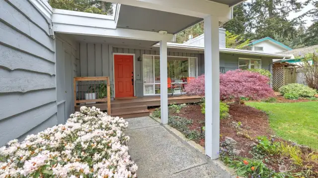 The front of the home offers a welcoming feel with the breezeway and beautiful landscaping.