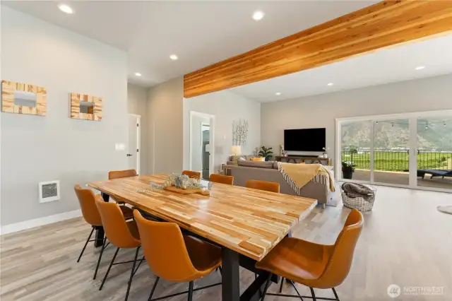 View 2 of the dining room designed to comfortably sit 8 guests that overlooks the living room & sitting area w. sliding glass doors leading out to the large lake view deck.
