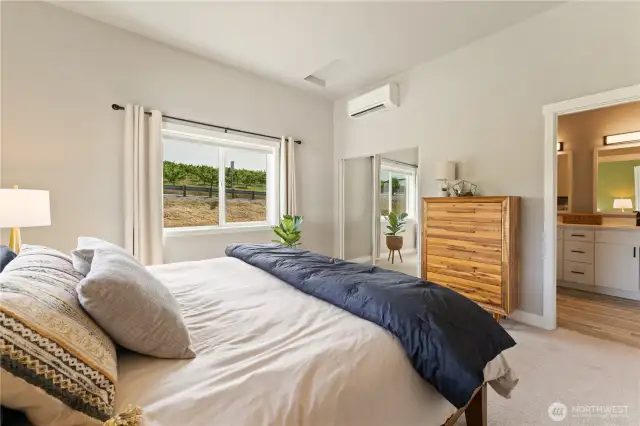 View 2 of the upper level Primary Bedroom suite w/ oversized windows & mirrored closet doors looking towards the Primary Bathroom suite w/ double sinks & a frameless glass & tile shower.