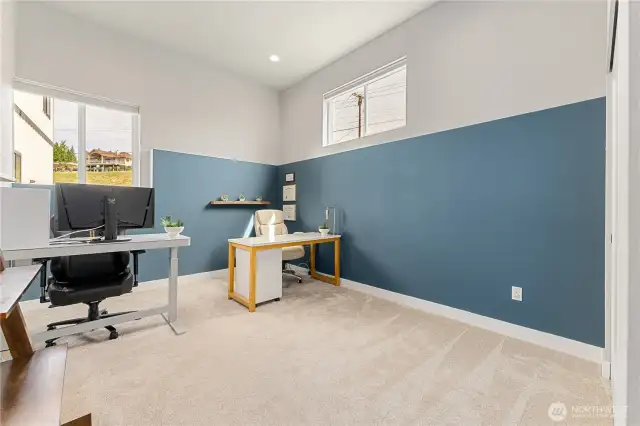 View of the lower level 3rd bedroom w/ extra tall ceilings, set up here as a home office.