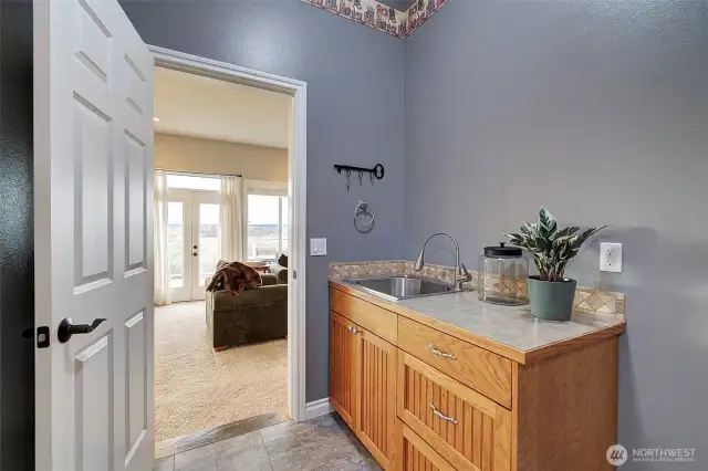 Main level utility room has hook ups for stacking washer and dryer