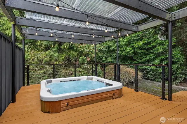 Just off the family room, a spacious east-facing deck features a covered area with a relaxing hot tub—perfect for unwinding year-round.