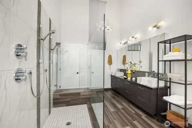 The primary bathroom features dual showers with sleek, frameless glass for a spa-like experience.