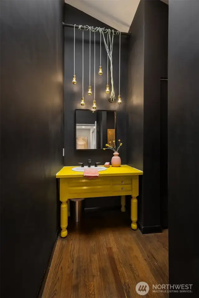 The main floor powder room delights with its playful charm, featuring custom design and eye-catching lighting that always sparks conversation.