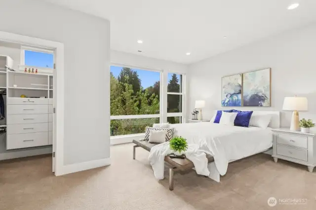 Spacious primary suite with walk in closet and floor to ceiling windows