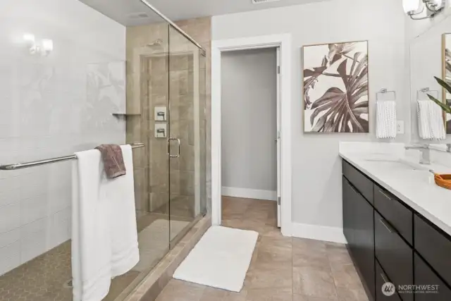 tiled double head shower with glass doors, quartz counters upgraded faucets, tiled floor