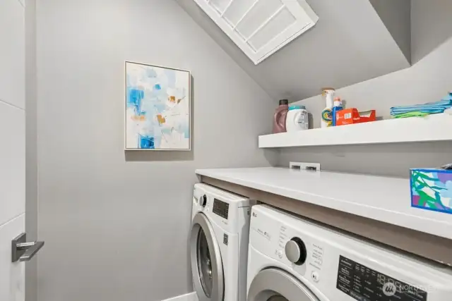 Laundry room with quartz counter and clothes rack above