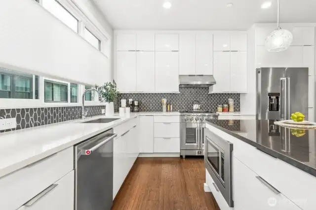 Rare Black quartzite island - a natural stone, not engineered for more durabliity and less maintenance. white quartzite counters in kitchen with top of the line tile surround.