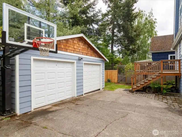 Another look at detached garage with backyard and deck.