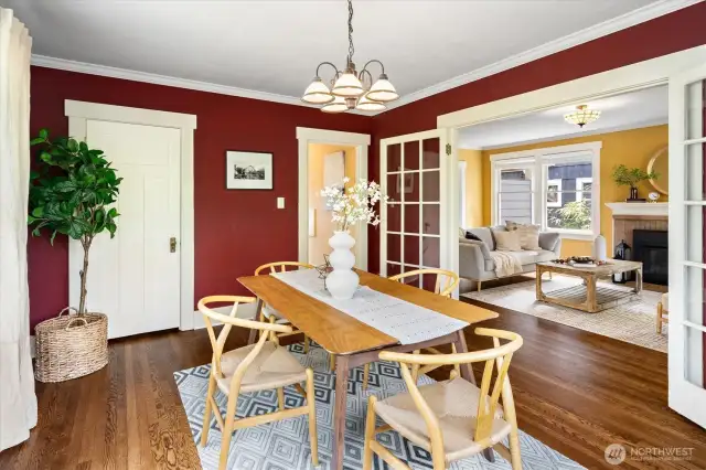 Dining room with closet. Refinished hardwood floors flow into the living room beyond the glass doors.