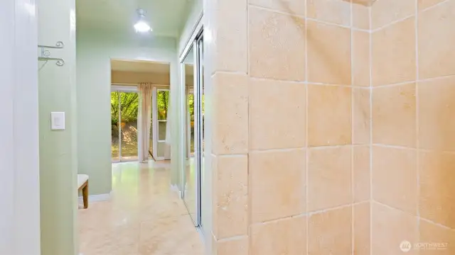 The shower in the primary three-quarter bath features beautiful real stone tile that adds a touch of luxury to your daily routine.