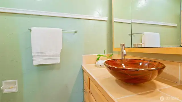 The main full bathroom on the lower level is beautifully finished and features another stunning vessel sink that adds style and flair to the space.