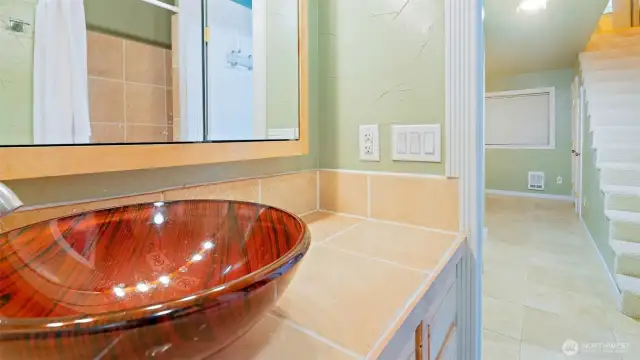 At the base of the stairs, this main hall bathroom features a full-sized tub and shower combination, ideal for everything from a relaxing soak to the daily get-up-and-go routine. Bright, clean, and ready for everyday comfort.