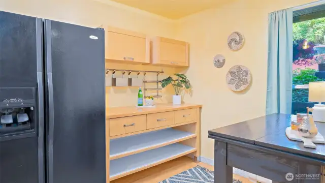Tucked beyond the fridge is even more kitchen space - complete with enclosed overhead storage, extra drawers, and bonus prep space. Everything you need, right where you want it.