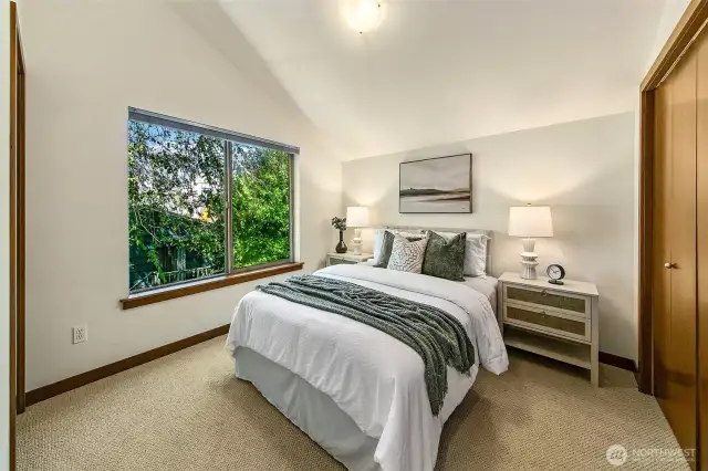 Heading upstairs is a generous primary suite with vaulted ceilings