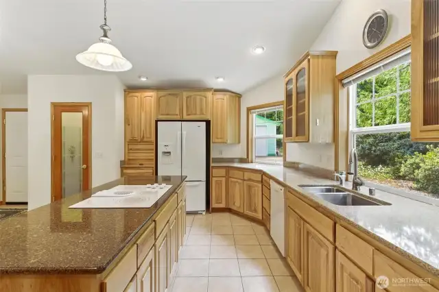 This beautiful kitchen features granite countertops, an instant hot water dispenser, and a spacious walk-in pantry—perfectly combining style and convenience.