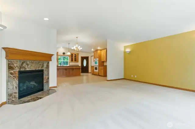 A central fireplace, soft natural light, and thoughtfully placed windows create a cozy atmosphere.