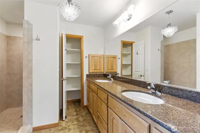 The primary bathroom is a true retreat, thoughtfully designed for both comfort and style. A deep, beautifully tiled walk-in shower offers a spa-like experience.