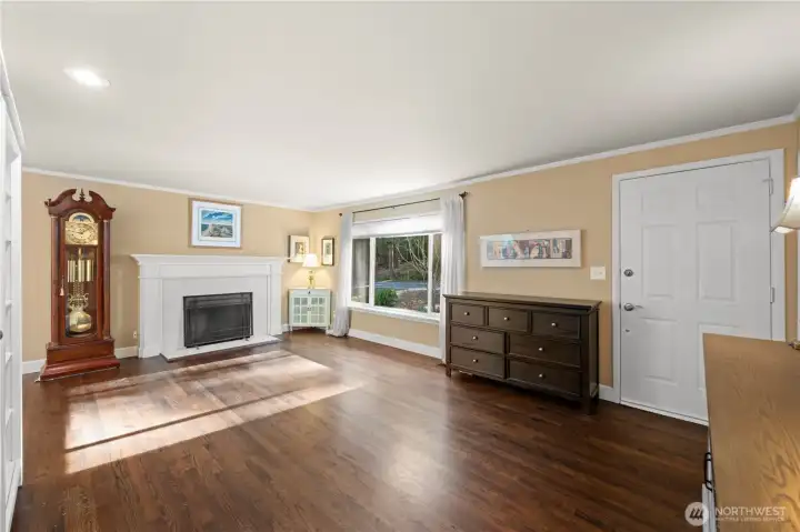 Spacious living room with beautiful oak hardwood floors, lots of natural light & fireplace.