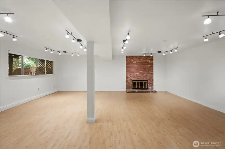 Lower level: bright rec room, backyard access, beautiful brick fireplace, high ceilings, lots of natural light & 1 bed/1 bath. The door leads out to the large fully fenced, level backyard w/ oversized patio.