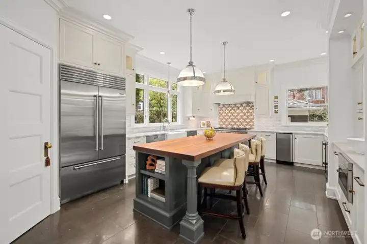 Heated limestone floors, custom hardwood cabinetry to the ceiling, quartzite stone countertops and marble backsplash with obscured outlets.