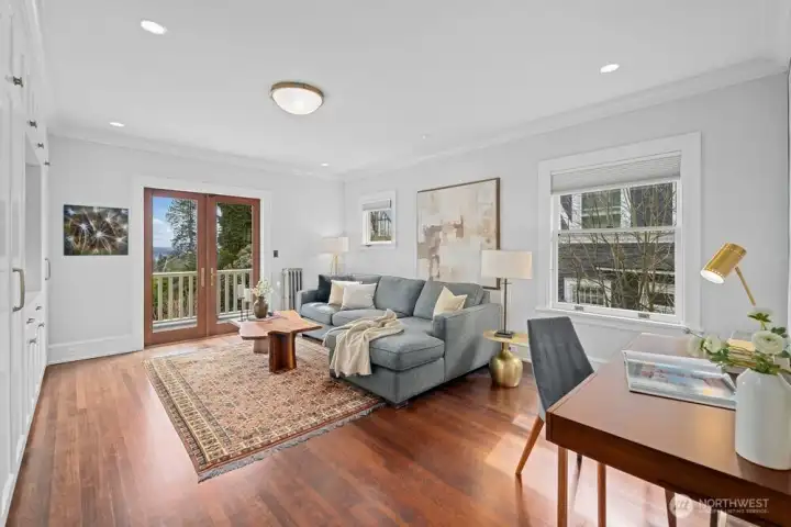 One of the bedrooms on the second floor is currently used as a sitting room for the primary suite. Engage with nature by opening the French doors to the 2nd floor balcony.