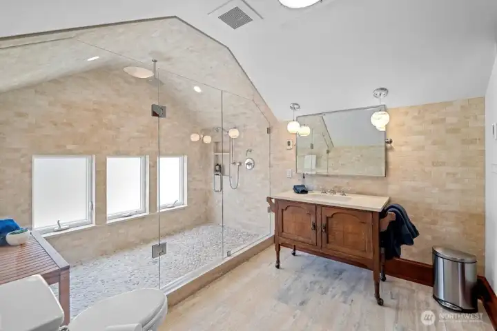 3rd floor custom bathroom with river rock shower flooring.
