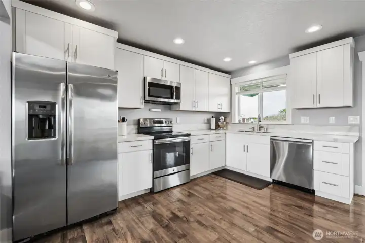 Bright white kitchen cabinets, light gray paint and stainless steel appliances provide a neutral backdrop for your decor.