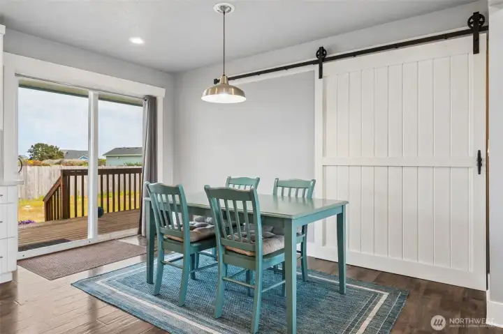 The glass sliding door leads to the expansive back covered porch and back yard. The "barn door" conceals the washer & dryer.