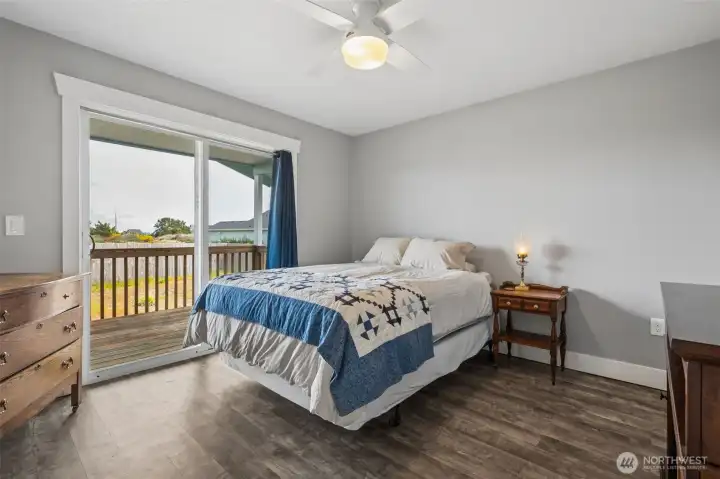 The primary bedroom has it's own sliding glass door that leads out to the back covered deck. There is a 3/4 bathroom in the primary.