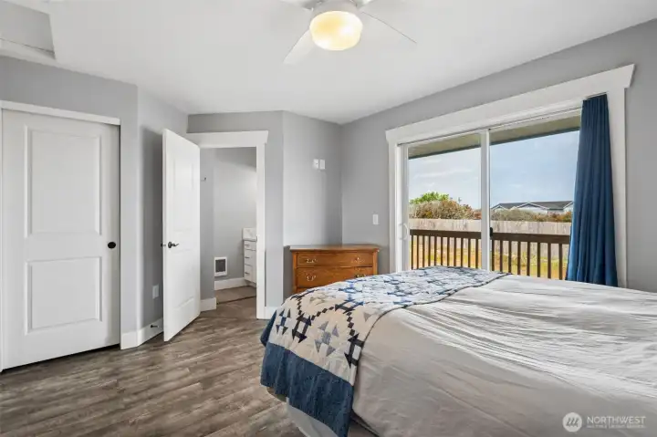 Primary bedroom with closet on the left, 3/4 bathroom center and sliding glass door to back deck & yard.