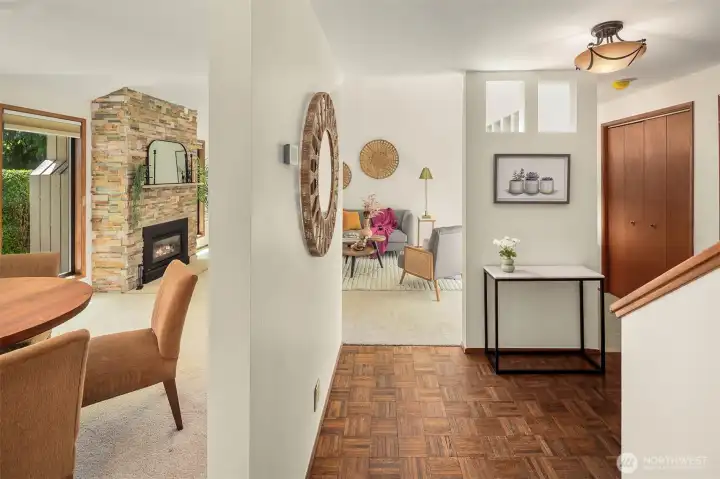 Another view of the foyer. To the right you see the hallway that leads to three main floor bedrooms and tons of storage. The living room and dining room are glimpsed here, as well as the stunning gas fireplace and the slightest snippet of the green views toward the backyard. So much to love!