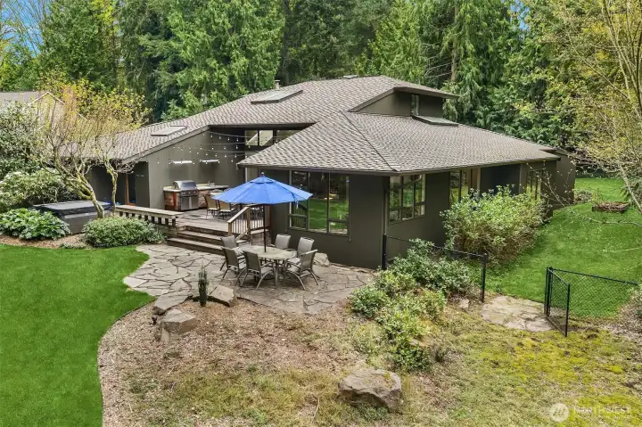 Flagston patio for extra outside dining surrounded by lush vegetation, lush lawn Flagston patio for extra outside dining surrounded by lush vegetation, lush lawn
