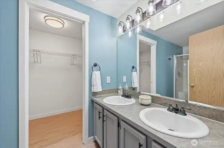 Primary bathroom with dual sinks and large walk-in closet