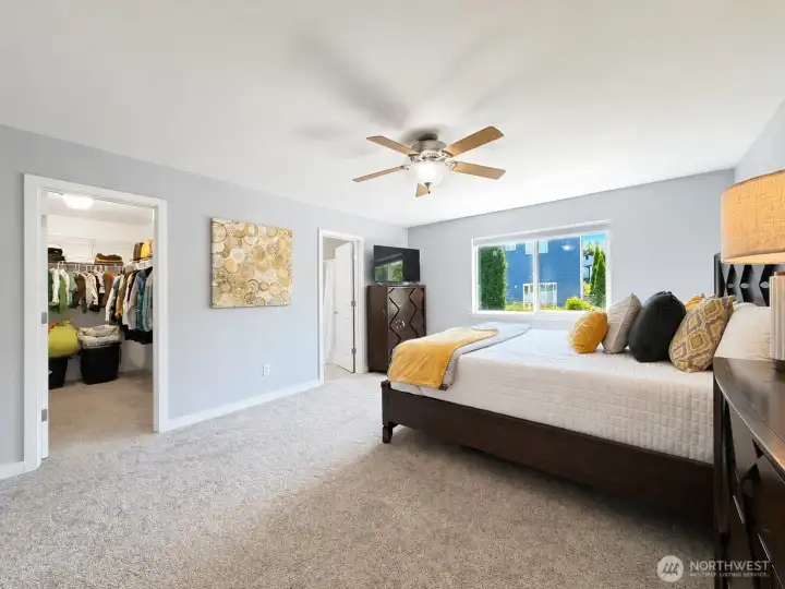 Primary bedroom w/ walk in closet and en suite bathroom