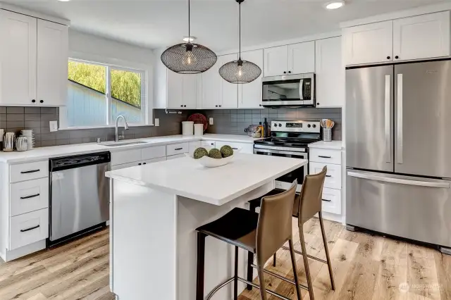 Spacious kitchen with central island featuring casual eating space—ideal for quick meals and socializing while cooking.