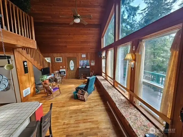 Vaulted ceiling living room flooded with light from the wall of windows.