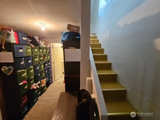 Storage area and stairs to the upper bonus room and doorway for the full bathroom in the garage.