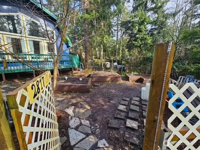 Enter through the gate into the raised-bed gardens on the way to deck and the back door for entrance.