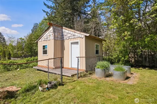 Detached studio/office with porch in fenced side yard