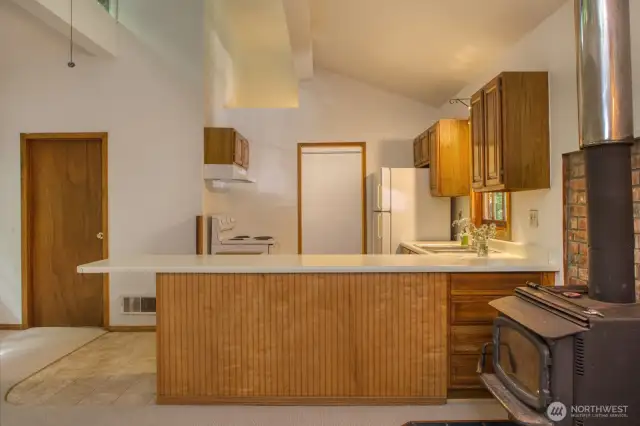 Kitchen is spacious for a cabin!  Wood stove, vaulted ceilings, laundry room & bathroom all easily accessible.