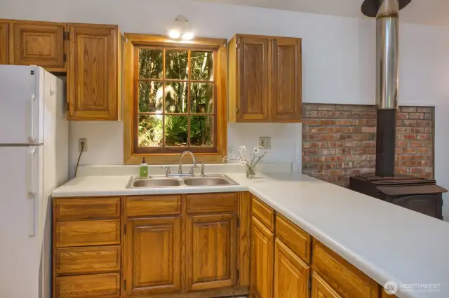 Double sink, refrigerator and wood cabinets.