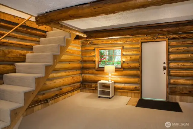 Inside offers the log cabin vibe with sunken living room and exposed log interior.