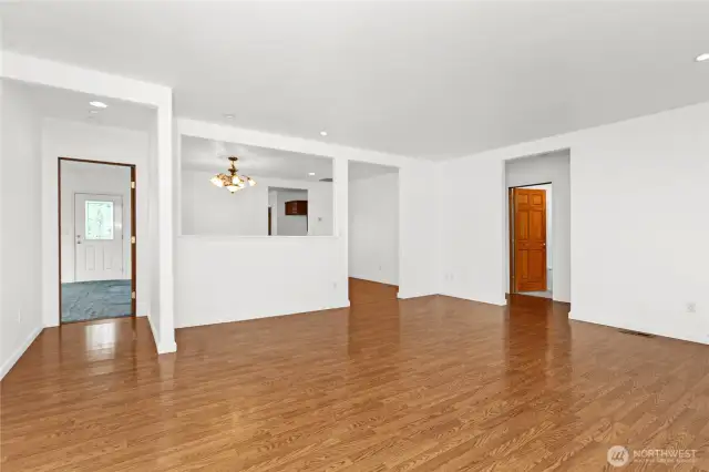 Living room with primary suite entrance on the left and hallway to bedrooms and main bath to the right