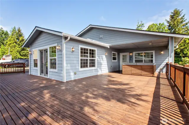extra large deck with a 6 person hot tub, door to primary suite and French doors leading to the eat in kitchen