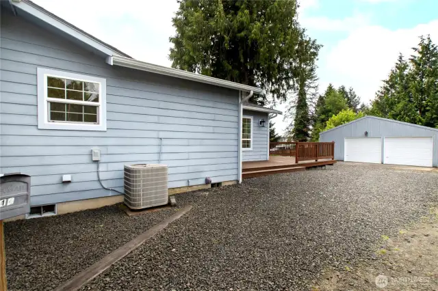 Side of house with large shop in background.