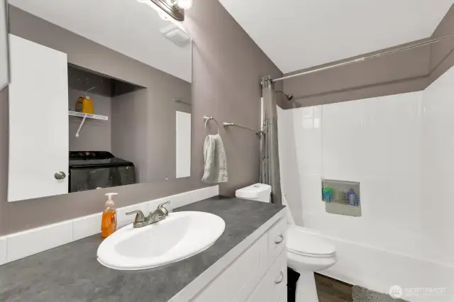 Large main bathroom with tub and shower plus storage.