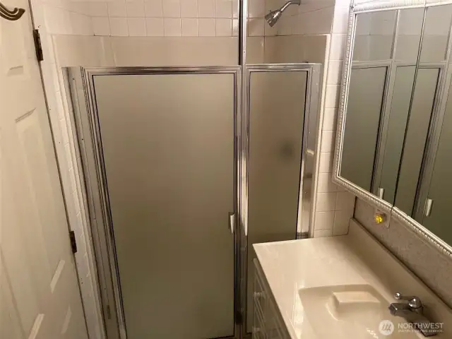 Primary 3/4 Bathroom: Shower with insert and tile. Cultured marble sink and three pane vanity and medicine cabinet.